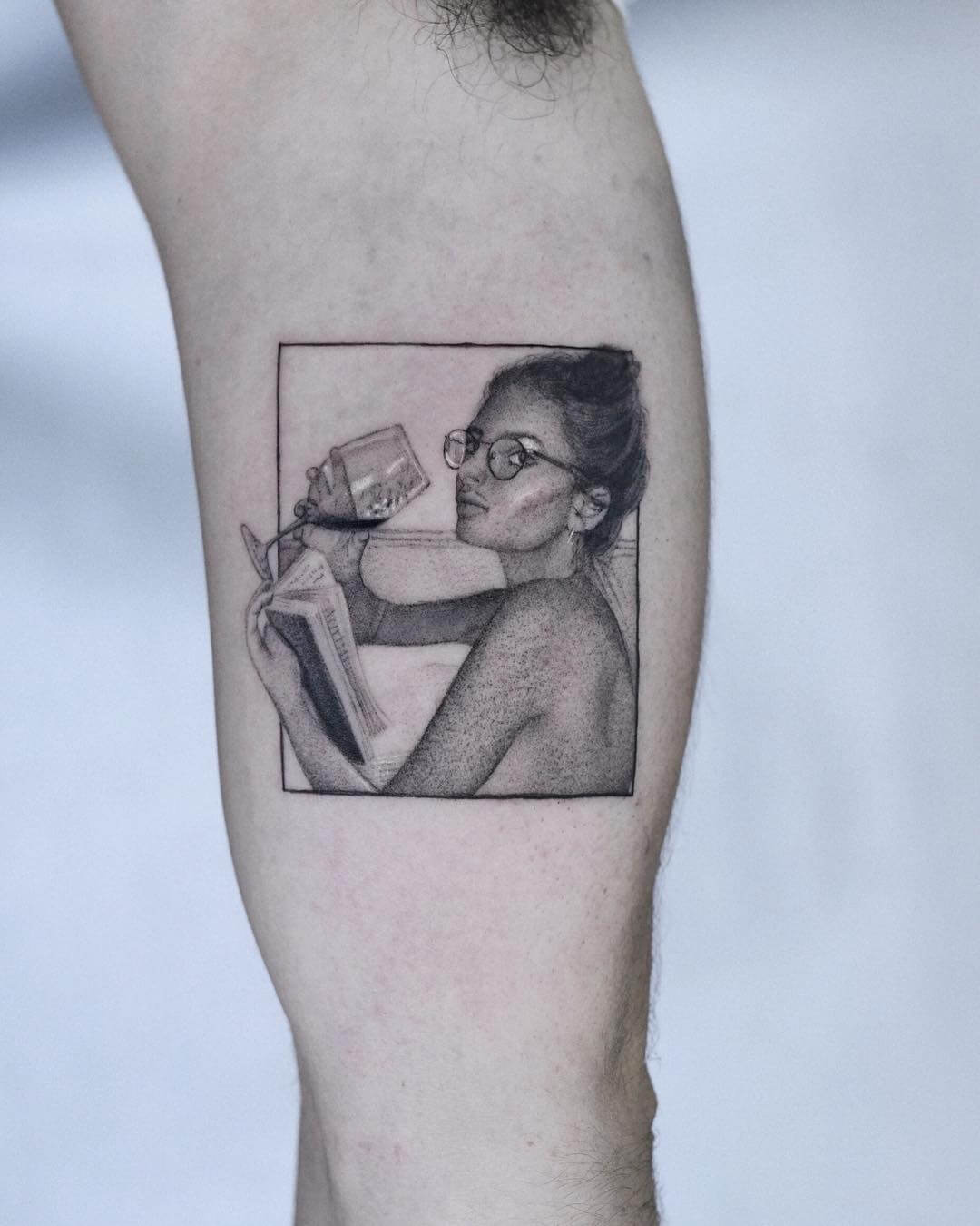 Woman holding glass of wine reading a book tattoo
